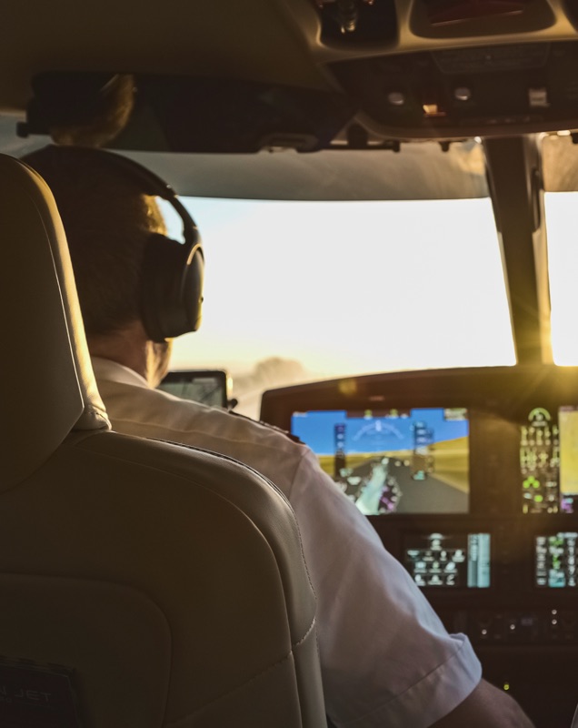 Pilot at the controls in a sunlit cockpit