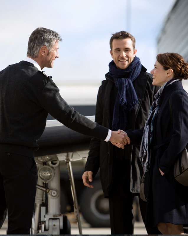 Concierge greeting clients beside an aircraft on the ramp